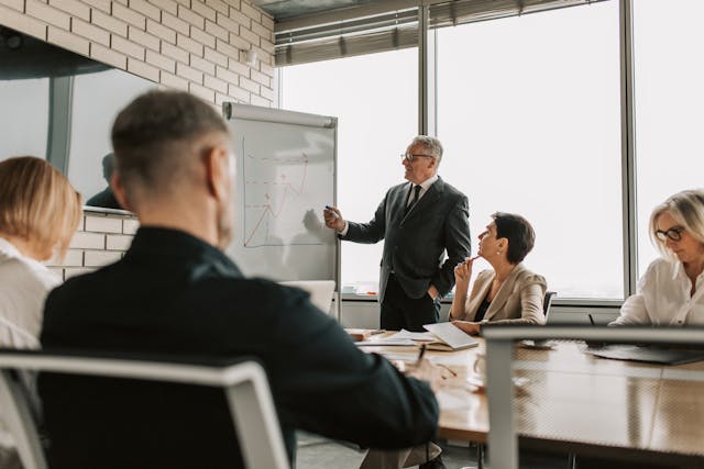 Profissionais de finanças reunidos em uma sala de diretoria corporativa, alinhando KPIs e indicadores estratégicos.