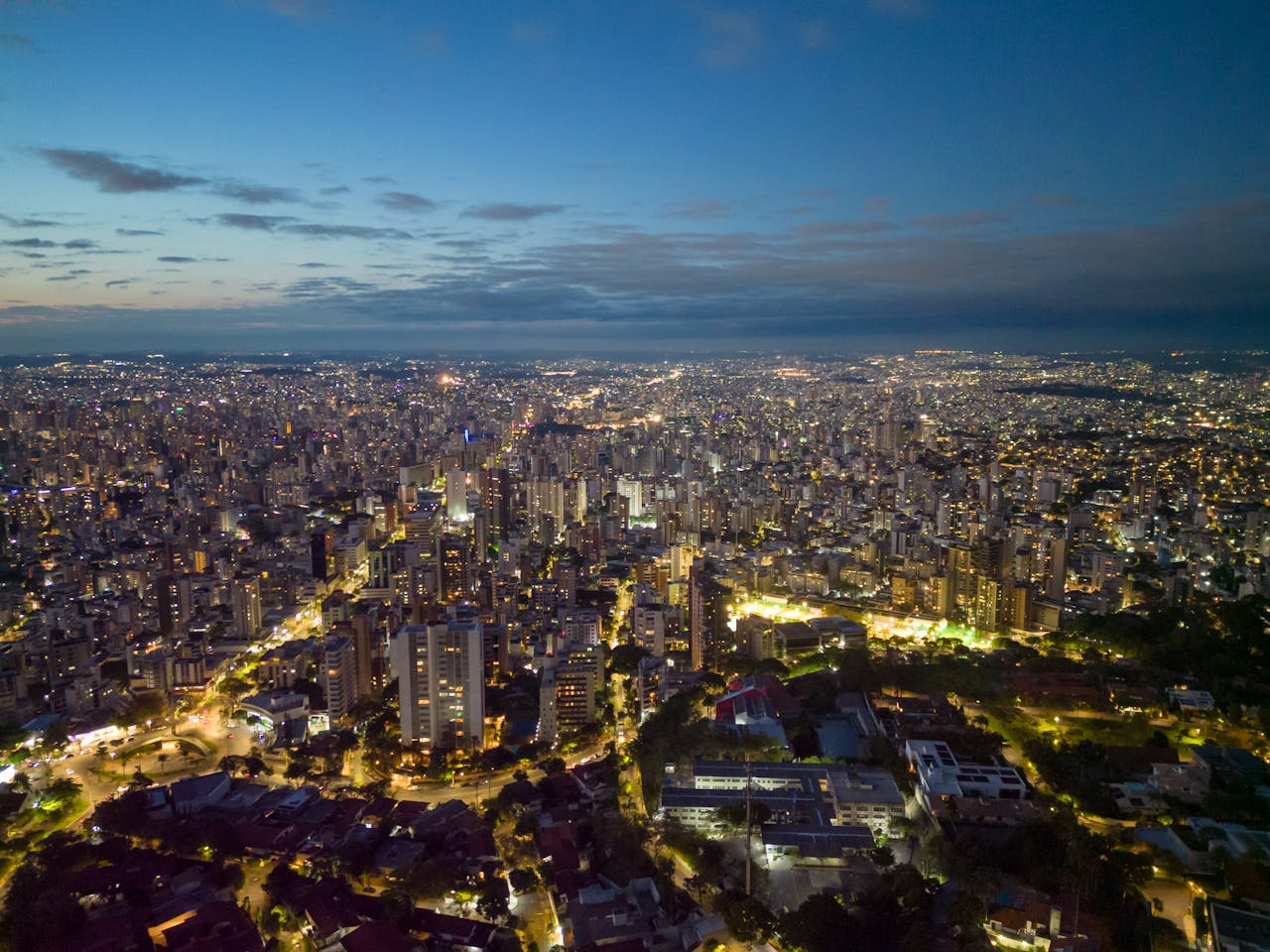 Vista panorâmica do horizonte de uma metrópole iluminada à noite, simbolizando o futuro da tributação e o crescimento empresarial.
